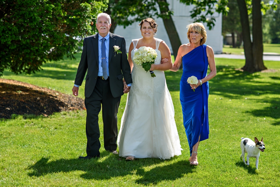Two parents walk their daughter to meet her new bride.